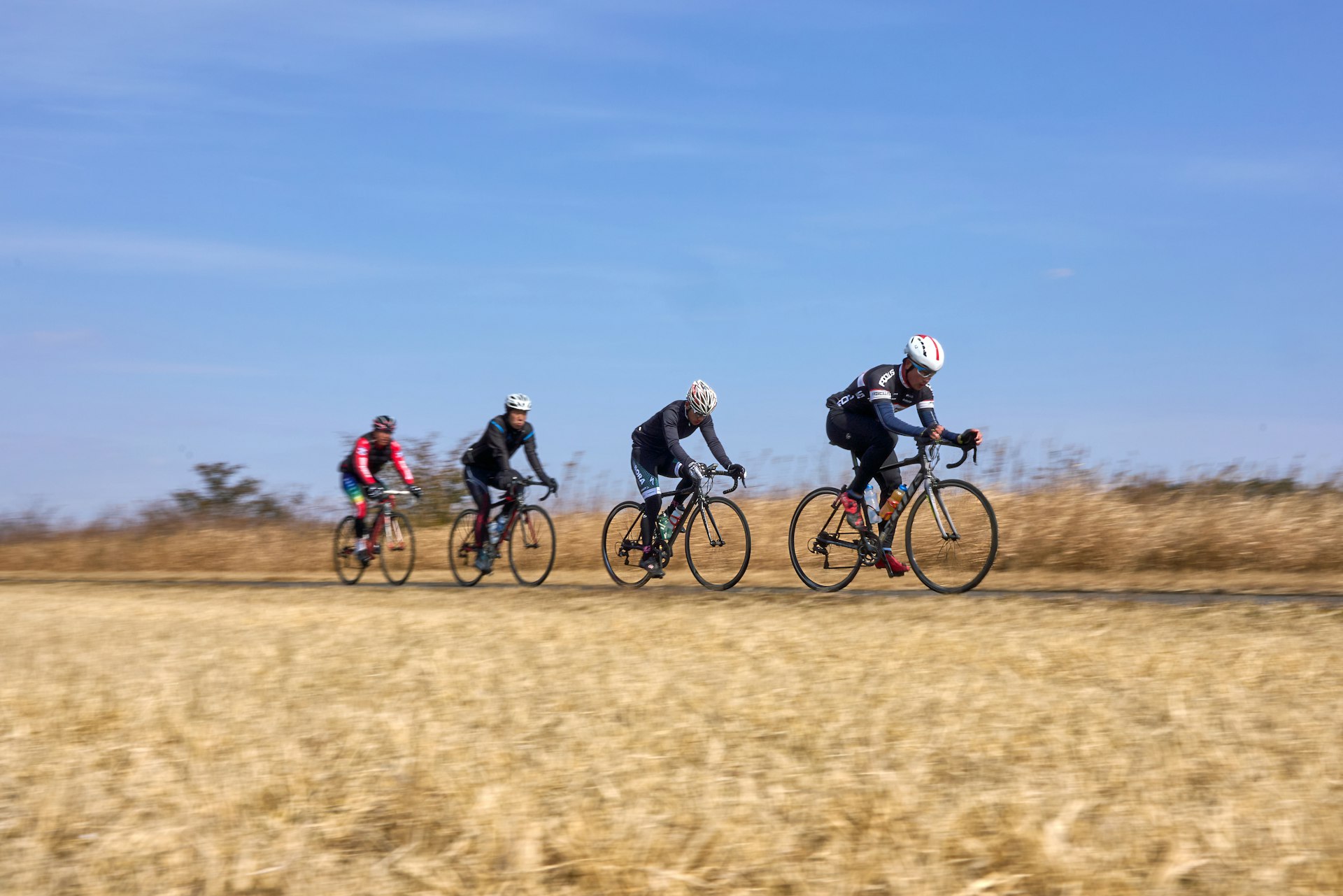 A group of people riding bikes down a dirt road